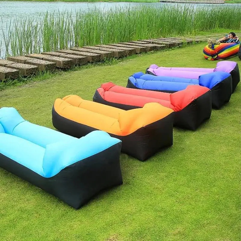 Colorful Relax™ Inflatable Sofa Beds arranged on grass, available in multiple shades. Perfect for outdoor use, camping, and travel convenience.